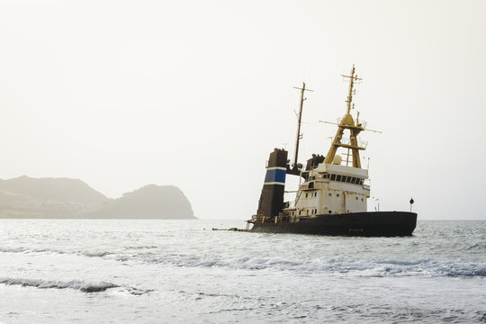 An abandoned ship is anchored close to shore in Mindelo, part of Cape Verde, Africa.