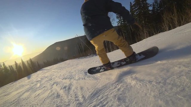 Active man snowboarder riding on slope. Snowboarding closeup.