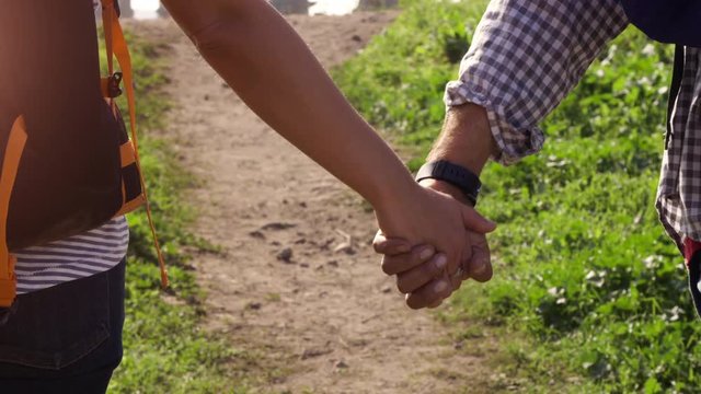Young lovely couple backpackers tourists walking holding hands toward roman aqueduct arches in parco degli acquedotti park ruins in rome on romantic misty sunrise with guitar and sleeping bag slow