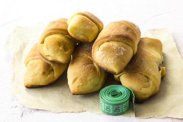 Buns with tape measure, junk food and diet time concept