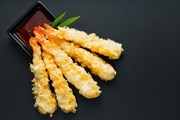 Traditional japanese tempura shrimps
 with sauce, deep fried shrimps top view on the background 