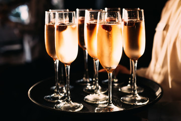 waiter carrying a tray with a glass of champagne