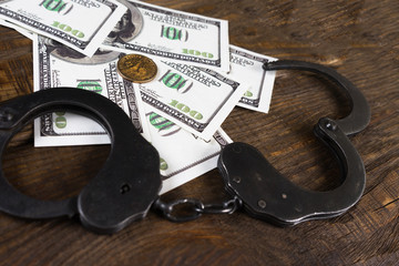 Obraz premium Handcuffs on a pile of American banknotes. The symbolic meaning of economic crimes.