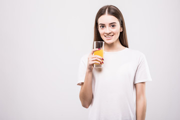 Young woman drinking orange juice. Beautiful face of woman close up with glass of orange juice isolated on white background