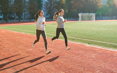 Two fitness running female jogging on athletics stadium