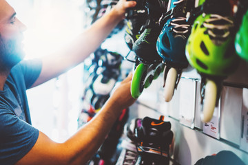 Assortment roller skates isolated in store shop, person choosing and buy color roller-skates on backgraund sun flare, healthy and activity lifestyle concept close up, man consider sport footwear