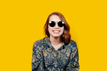 Naklejka premium Photo of excited happy young woman standing isolated over yellow background. Looking camera.
