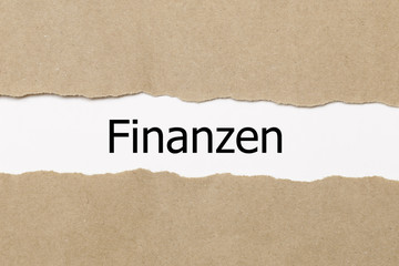 Fototapeta na wymiar Finanzen (german for financial) written behind a torn paper