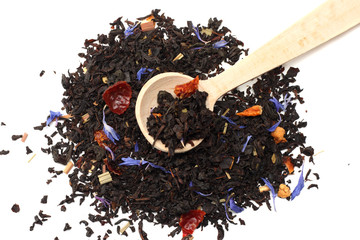 Aromatic black dry tea with petals in wooden spoon isolated on white background