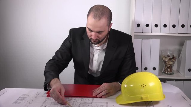 Businessman architect studying building blueprints chief constructor in office