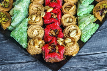 Turkish dessert. Oriental sweets with nuts and honey on a wooden background.