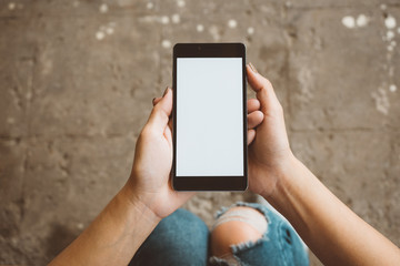 Hand holding black mobile smart phone with blank white screen at outdoor to checking e-mail or social network. technology and lifestyle concept.