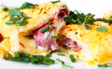Egg omelette with ham and cheese and green herb.