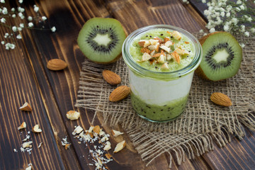 Milk yogurt with kiwi and nuts on the rustic  wooden background