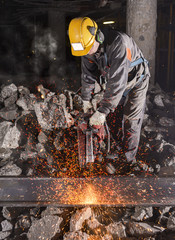 Construction worker cutting an iron beam.