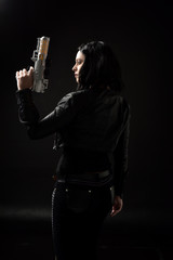 portrait of black haired girl wearing leather clothes, moody lighting on black background.