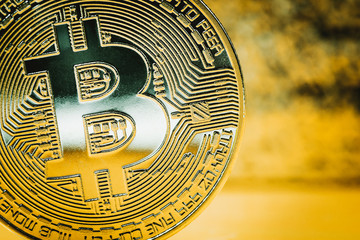 Golden bitcoin on a blurred background. Close up