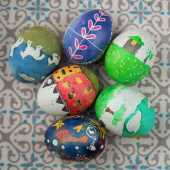 Cute kid Hand painted easter eggs on a patterned plate