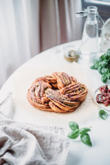 Pesto and dried tomatoes babka on white rustic background. Homemade bun. Traditional french cuisine. Selective focus