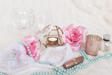 Valentines Day concept. White bra with wine glasses, roses and candles on white textured background. Isolated.