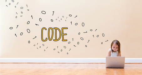 Code text with little girl using a laptop computer on floor