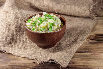 Traditional Russian festive salad Olivier on wooden table