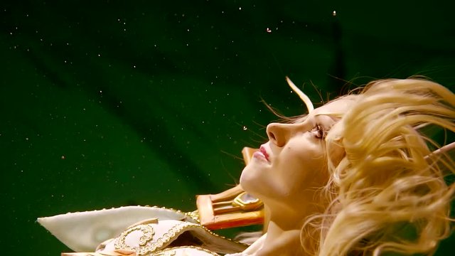 Close up shot of a lovely blone elf lonely floating under water on its back.