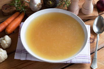 Bone broth made from chicken on a wooden table