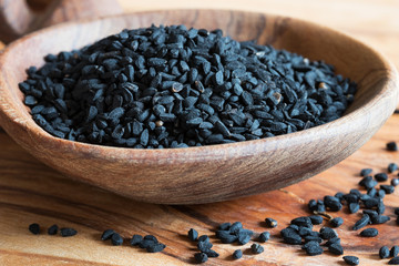 Black cumin seeds on a wooden spoon