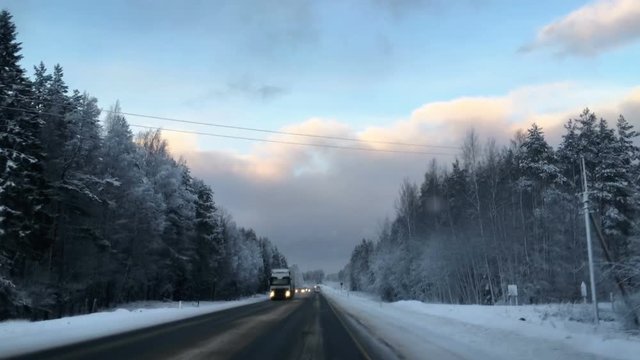 Car driving on wintry slippery highway, first person view from front windglass