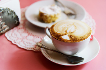 Cup of coffee in cafe with cake