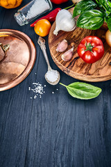 Italian food. Basil tomato and garlic on wooden black blackboard