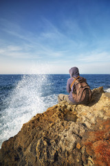 man admires the scenery on the edge cliff of the sea shore