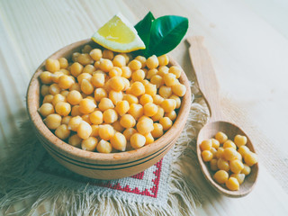 Rustic vegetarian food, cooked chickpeas peas in a wooden bowl with a wooden spoon.

