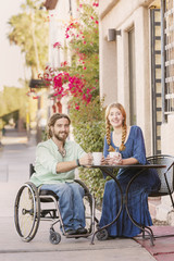Smiling Woman with Man in Wheelchair Outdoors