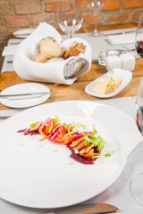Smoked salmon with roasted beetroots sauce, russian pancakes and horseradish cream served in a restaurant