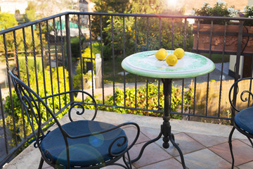Lemons on a forged table and chairs on the terrace on a Sunny summer day, overlooking the city and...