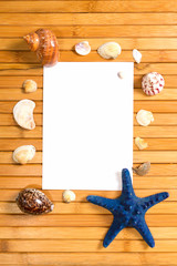 paper sheet on wooden background with seashells and starfish