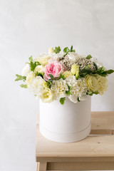 Beautiful tender bouquet of flowers in white box on light ackground with space for text