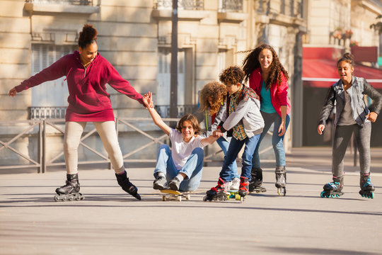Teenage inline skaters and skateboarder having fun