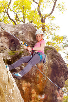 Teenage girl holding harness rope during downclimb
