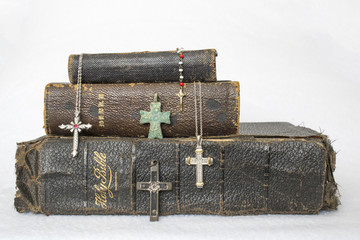 Antique Worn Leather Bibles with Antique to Modern Crosses on White Background