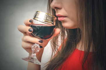 Woman is holding a glass of wine and taste it. Wine degustation.