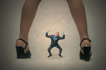 Female domination concept. Strict woman boss. A small man is affraid his angry big boss girl....