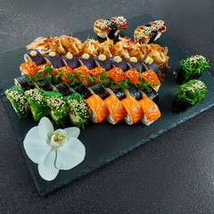 Sushi Set nigiri and sushi rolls on gray stone slate on metal background