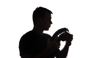 Fototapeta na wymiar Silhouette of a young man with a smartphone with headphones