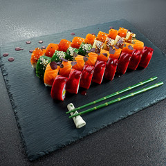 Sushi Set nigiri and sushi rolls on gray stone slate on metal background
