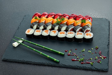 Sushi Set nigiri and sushi rolls on gray stone slate on metal background