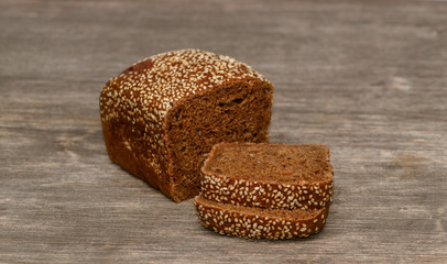 Delicious black bread on old tree background