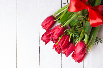 Bouquet of red tulips on white wooden background. Flat lay.